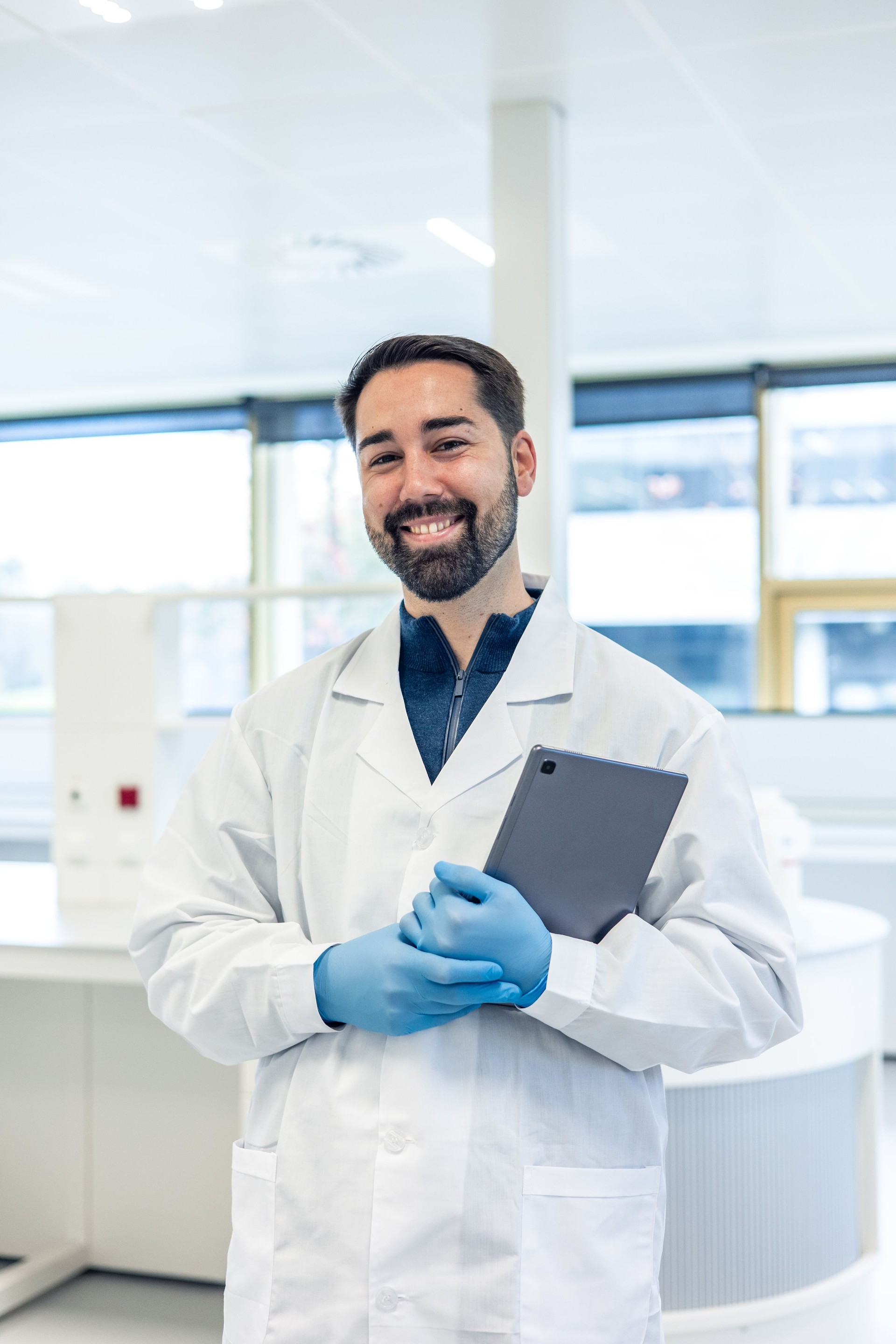 Scientist smiling and holding tablet in laboratory
